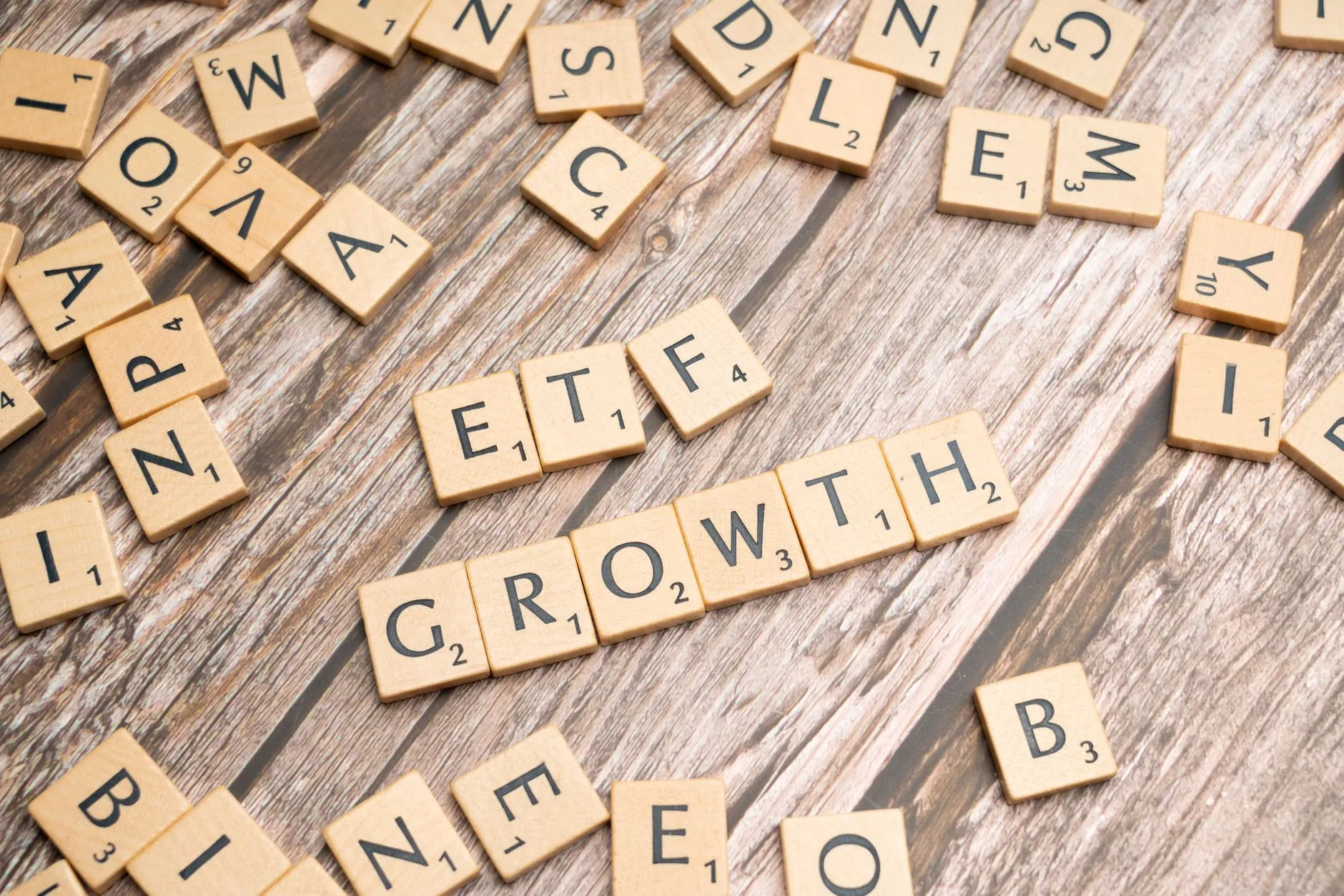 Wooden tiles spelling ETF growth on a wooden surface.