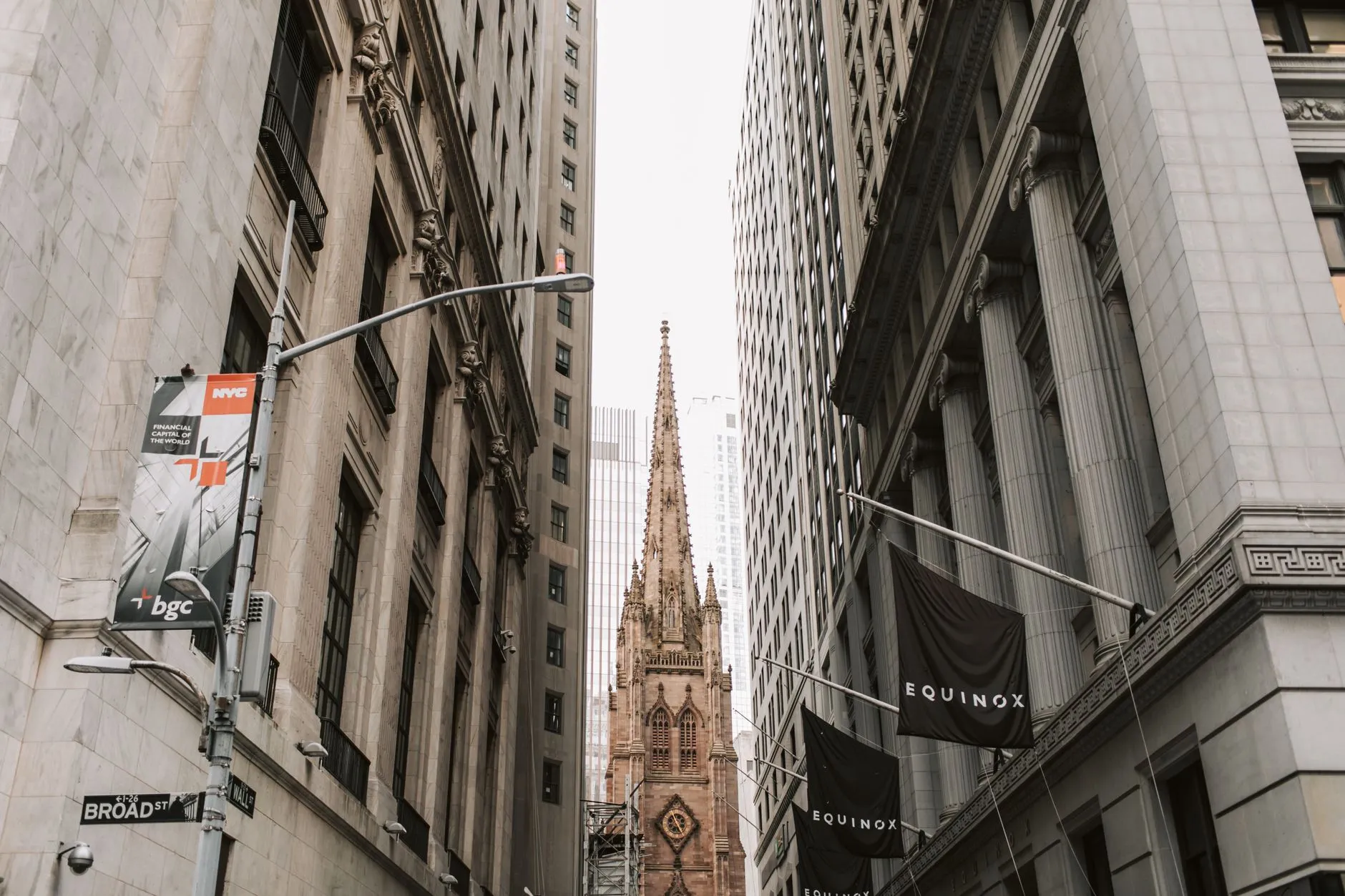 Trinity Church between skyscrapers on Broad Street in New York's financial district.